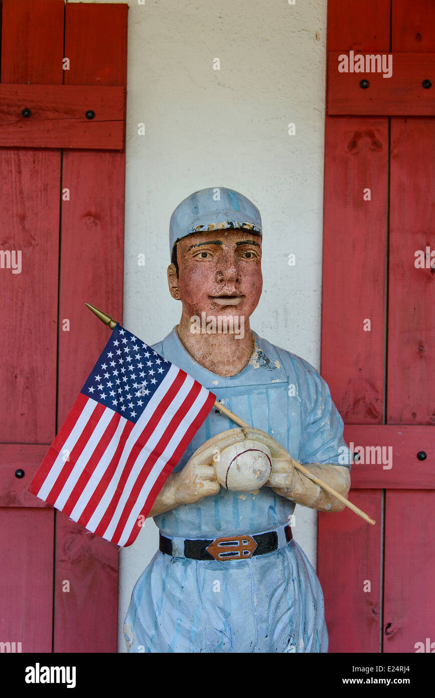 Eine Abbildung eines Baseball-Spieler halten die Stars And Stripes Flagge draußen ein Sportgeschäft am St. Armands Circle, Sarasota, Florida Stockfoto