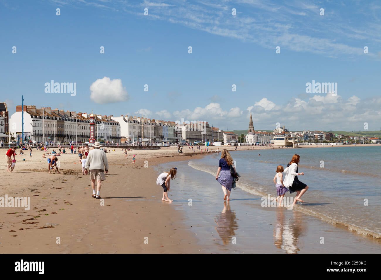 Menschen spielen am Strand an einem sonnigen Sommertag, Weymouth, Dorset England Südküste, UK Stockfoto