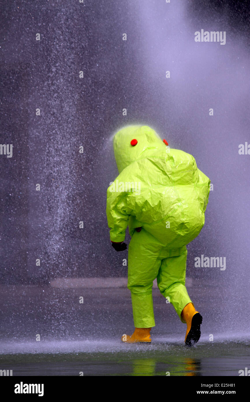 Arzt mit anti-Strahlung Anzug beim Waschen mit einem starken Wasserstrahl in den Gefahrenbereich Kontamination Stockfoto