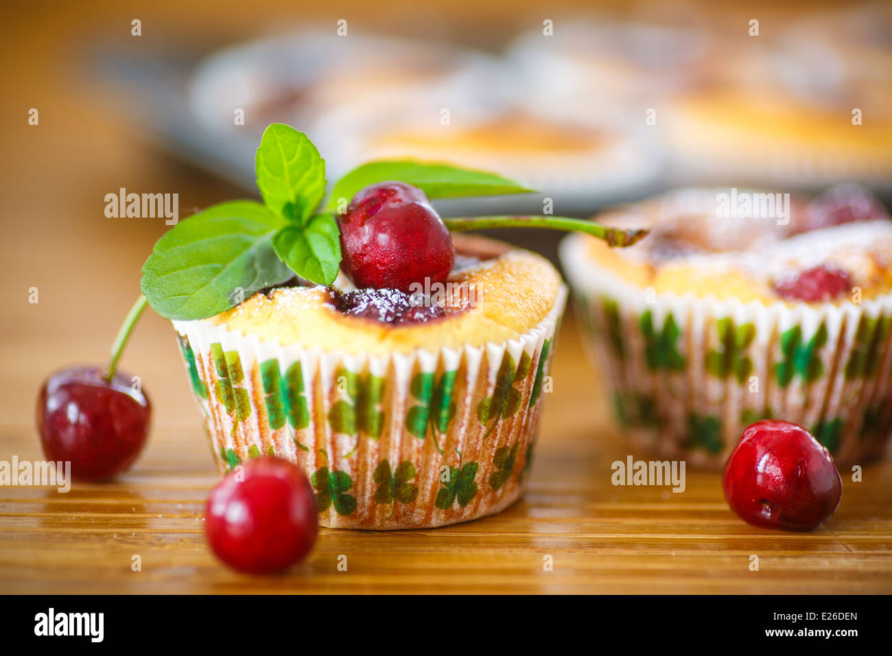 Käse-Muffins mit Kirschen und Minze-Zweig Stockfoto