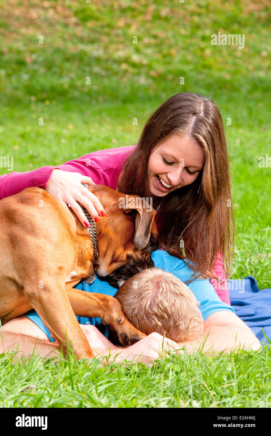 Glückliche junge Paar spielen mit ihrem Hund im Park. Stockfoto