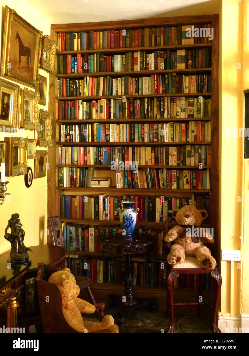 Eine altmodische Zimmer mit einem großen Bücherregal und ausgestopften Bären in Stühle Stockfoto