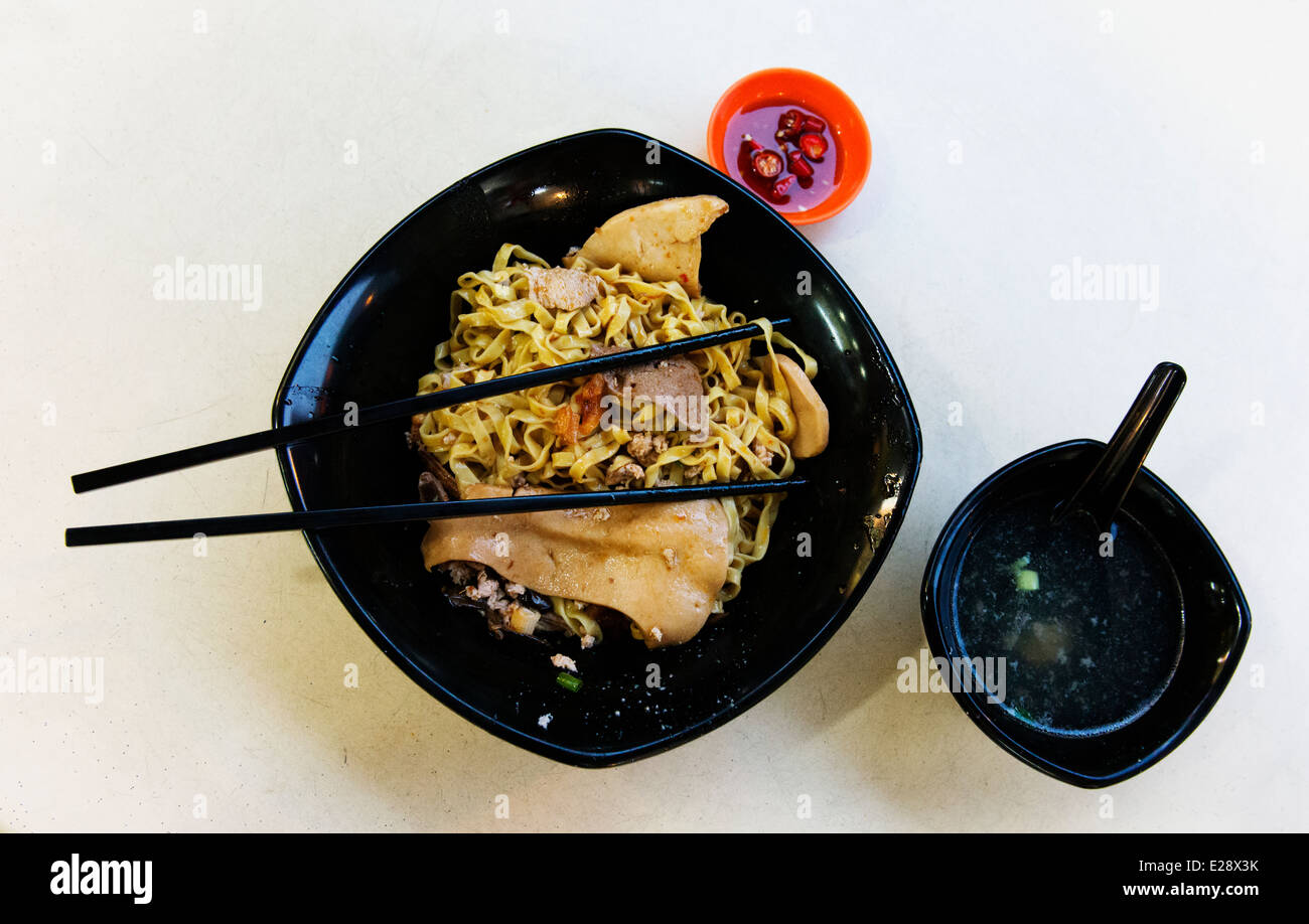 Nudelgericht mit Suppe und Chili auf der Seite war ein Singapur-Lebensmittel-Halle. Stockfoto