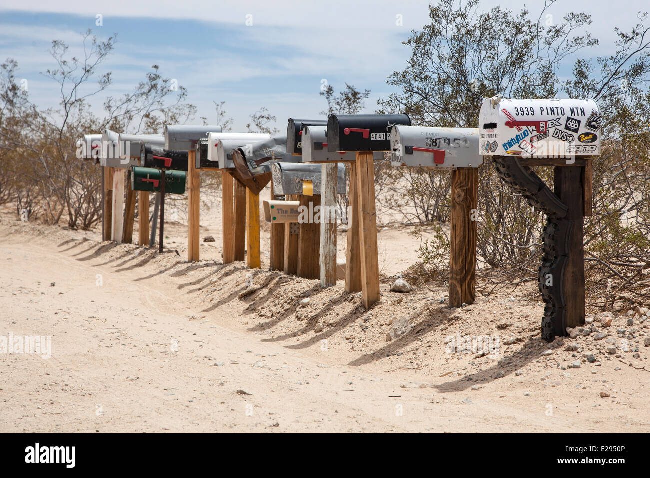 Reihe von US-Briefkästen auf Pfählen in der Wüste, California Stockfoto