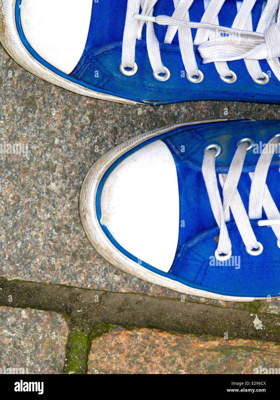 Füße in leuchtendem Blau canvas-Trainer Stockfoto
