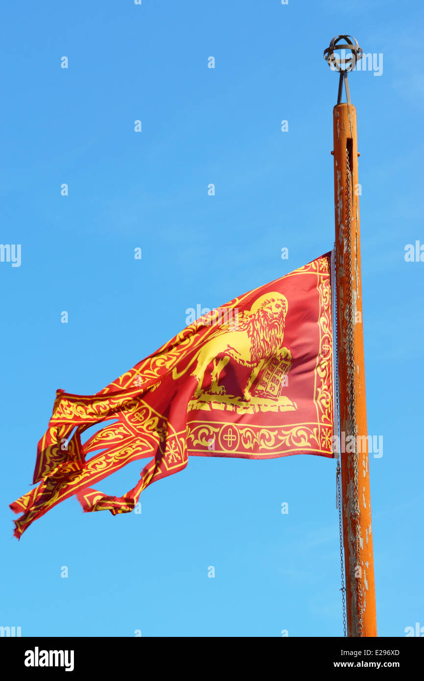 Flagge von der alten Republik Venedig winken gegen einen blauen Sommerhimmel in Venedig, Italien Stockfoto