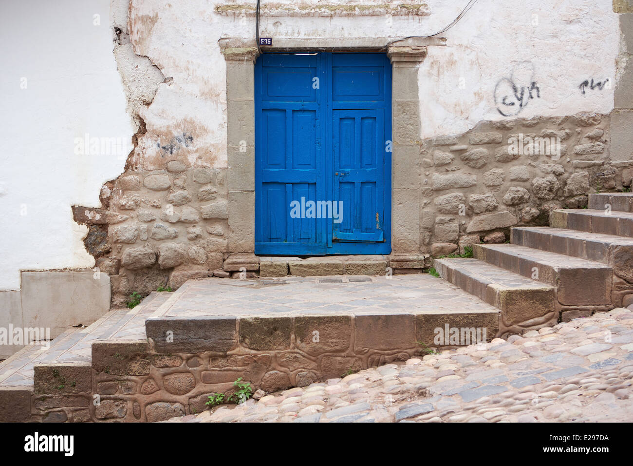 Eine ziemlich Straßenszene einer steilen gepflasterten Straße und blauen Tür in Cusco, Peru, Sitz des Inka-Reiches hoch in den Anden. Stockfoto Eine ziemlich Straßenszene einer steilen gepflasterten Straße und blauen Tür in Cusco, Peru, Sitz des Inka-Reiches hoch in den Anden. Stockfoto
