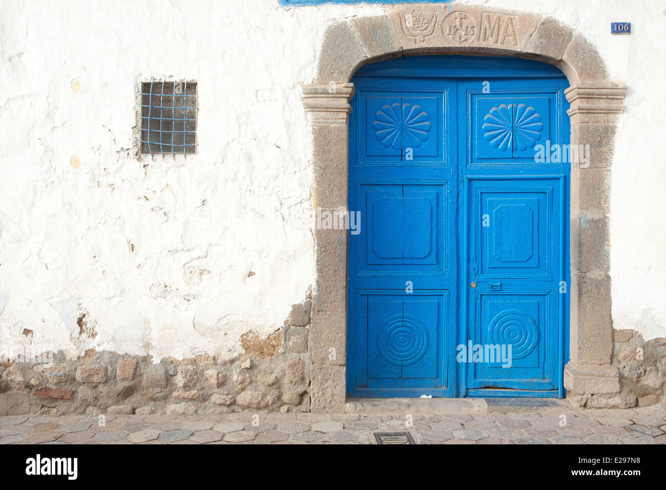 Eine ziemlich Straßenszene mit einer blauen Tür in Cusco, Peru, dem alten Sitz des Inka-Reiches hoch in den Anden. Stockfoto