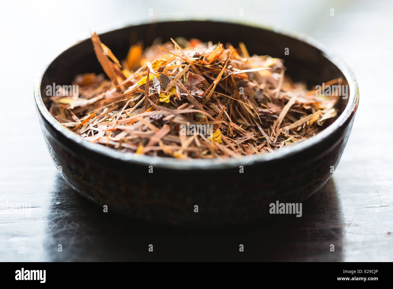 Rooibos Tee Blätter in eine Schüssel geben. Stockfoto
