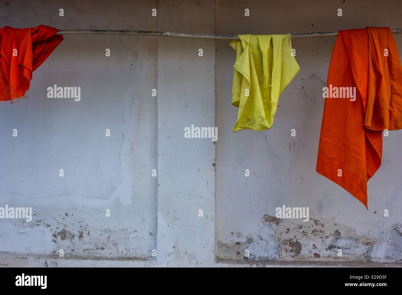 Safran Roben hängen in einer Zeile in der antiken Stadt Luang Prabang, befindet sich im nördlichen Laos, ein UNESCO-Weltkulturerbe. Stockfoto