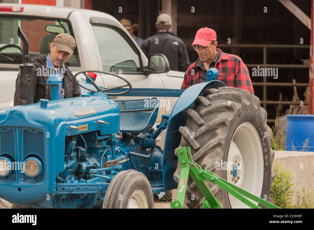 Zwei Bauern untersuchen einen Fordson Dexta Traktor bei einem lokalen Land-Auktion. Stockfoto