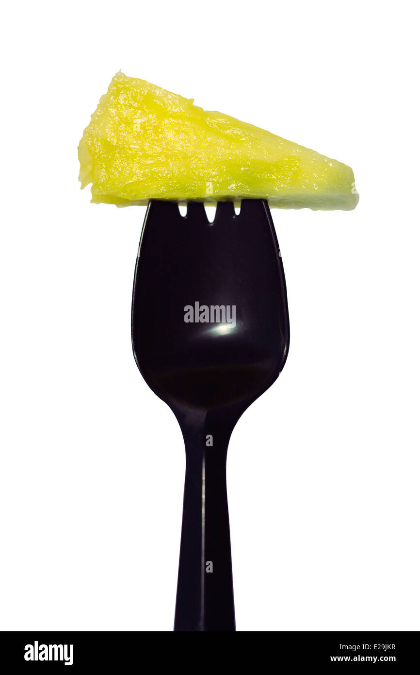 Schneiden Sie aus. Gelbe Ananas Stück auf einem schwarzen Kunststoff Spork auf weißem Hintergrund Stockfoto
