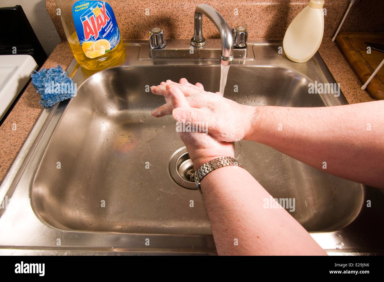 Seifenblasen für Hände des Mannes, wie er sie in ein Waschbecken wäscht Stockfoto