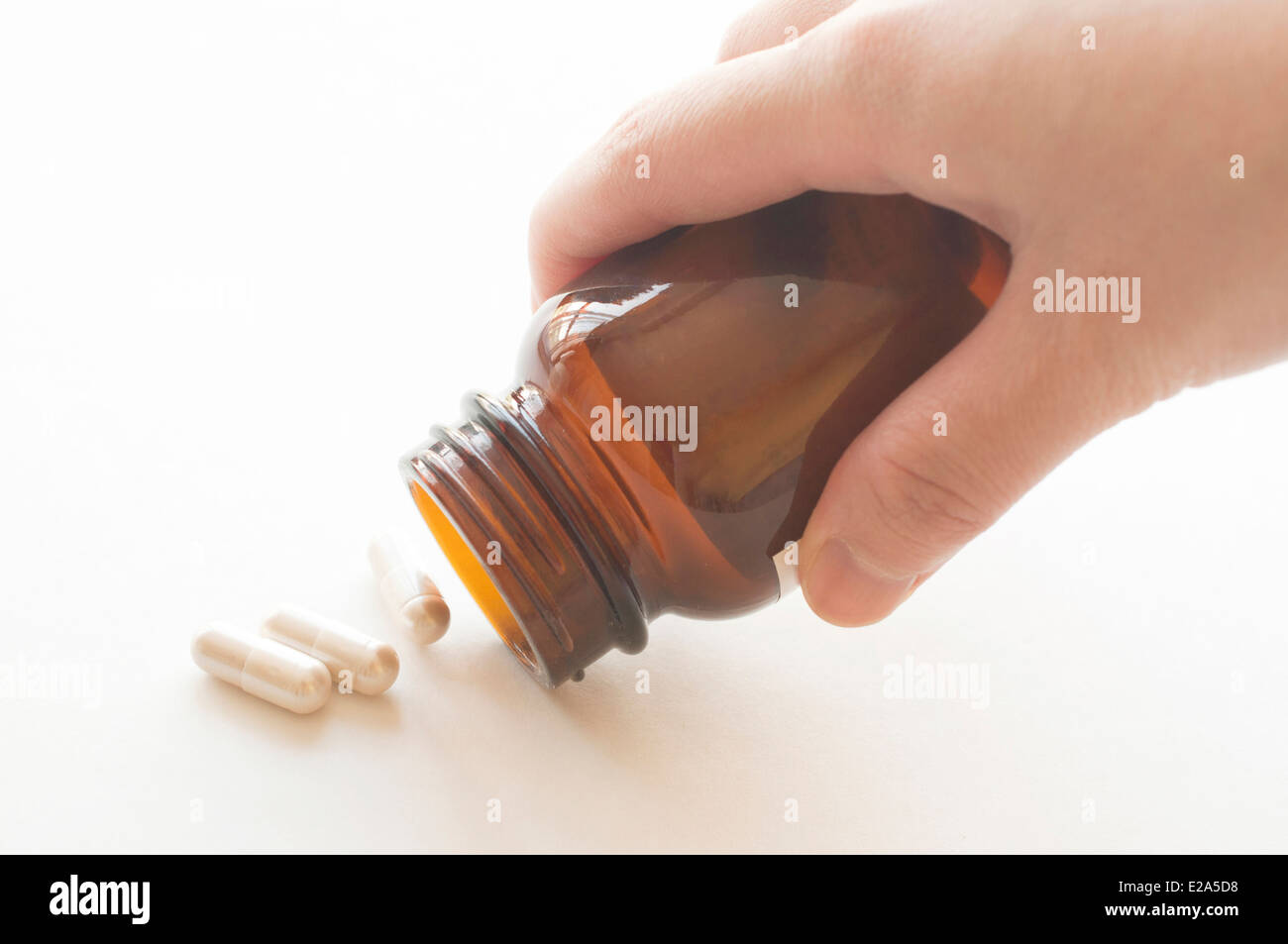 Strömenden Kapseln aus einer Pille Flasche, Schwerpunkt Flaschenhals Stockfoto