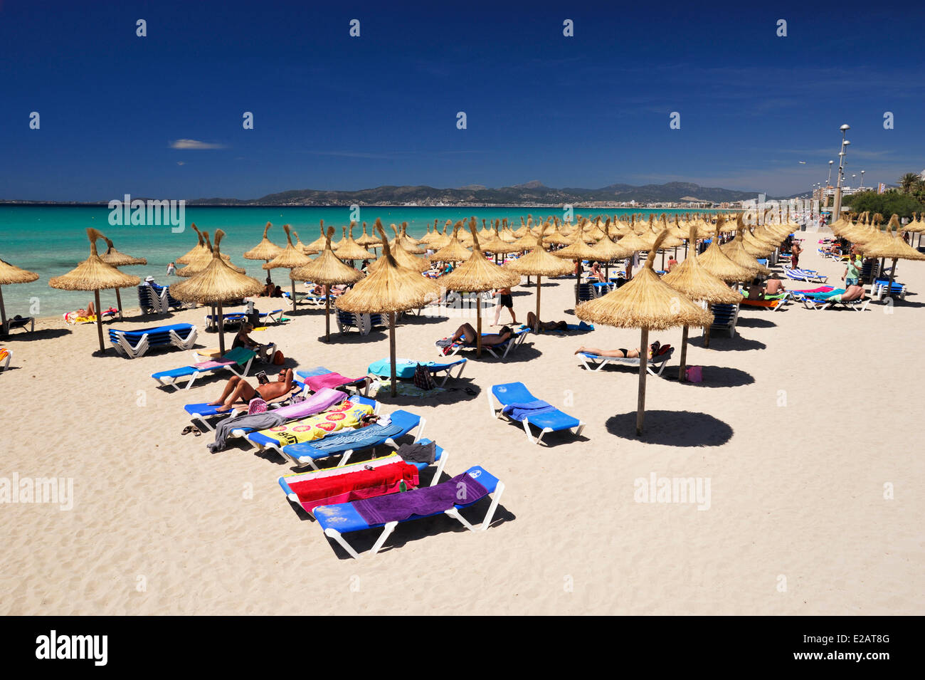 Spanien, Balearen, Mallorca, S'Arenal, El Arenal, Playa de Palma, Urlauber genießen den Schatten der Sonnenschirme ausgerichtet Stockfoto