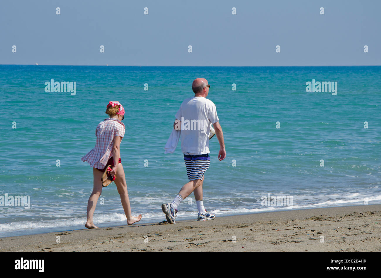 Ehepaar im Ruhestand zu Fuß am Strand in Fuengirola, Costa Del Sol, Spanien. Stockfoto