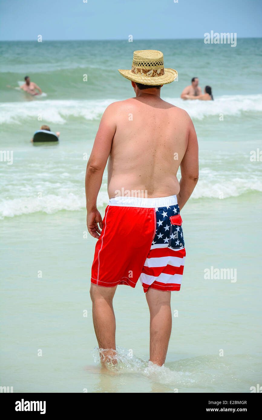 Ein Mann trägt seine patriotischen Sternenbanner Badehose am Strand am 4. Juli, USA Stockfoto