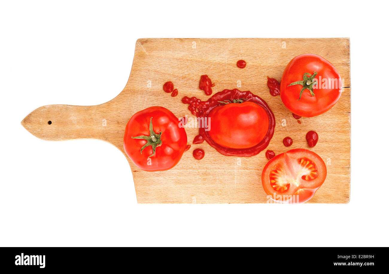 Tomaten-Ketchup mit Tomatenscheiben auf Holzbrett. Bespritzt Tomate mit Ketchup auf Schneidebrett Küche. Stockfoto