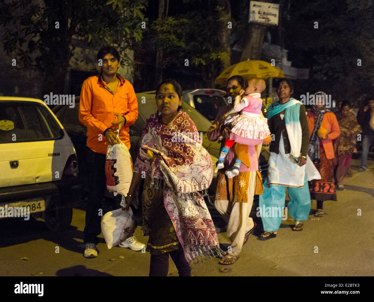 Eine indische Familie Spaziergänge entlang einer verkehrsreichen Straße in Neu-Delhi, Indien. Stockfoto