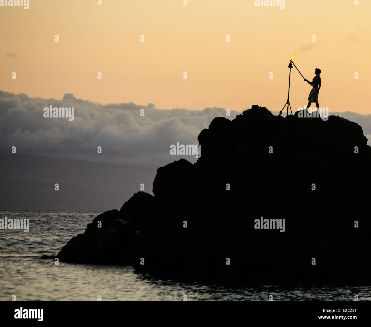 Mann Lichter Fackel auf Black Rock am Kaanapali Strand vor dem Tauchen von Klippe während Sonnenuntergang show Stockfoto