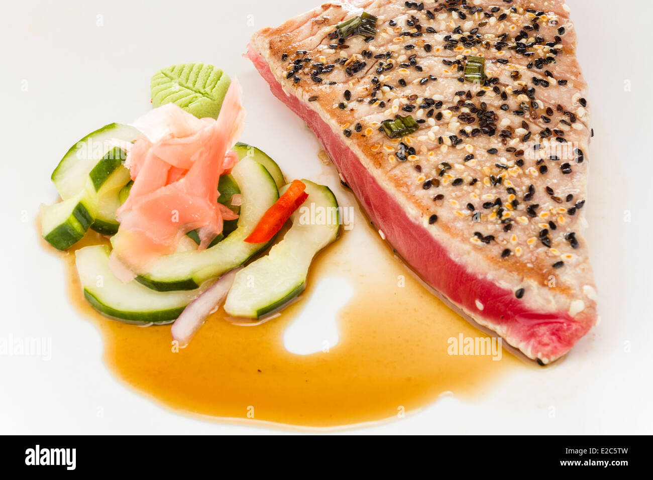 Sesam Käserand Thunfisch in Sauce serviert mit Gemüse und Wasabi Garnitur abgedeckt. Stockfoto