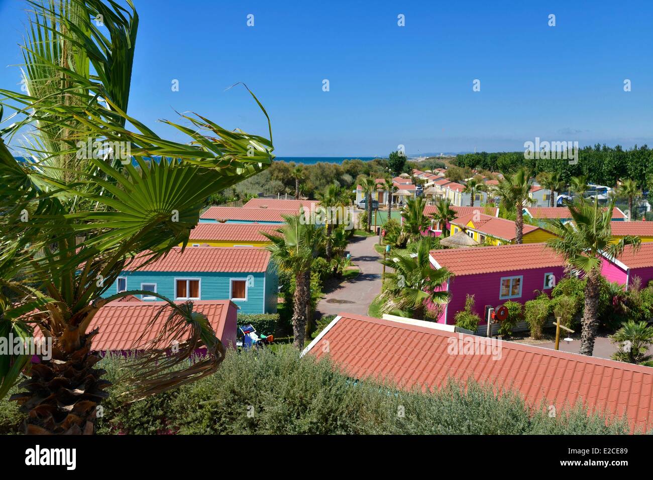 Frankreich, Herault, Serignan, Camping Village Aloha, farbenfrohe Häuser  unter Palmen Stockfotografie - Alamy
