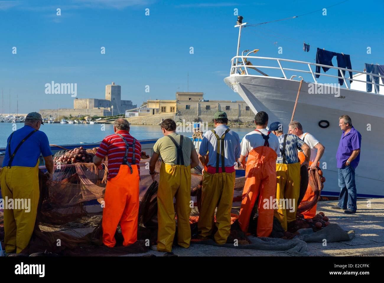 Altstadt, Fischereihafen, Männer, die Netze zu entwirren, bevor Trawler angedockt, Trapani, Sizilien, Italien Stockfoto