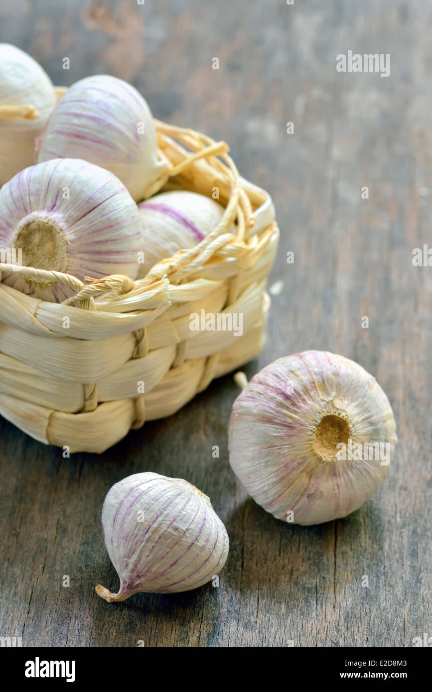 Violette Knoblauch in einem kleinen Stroh Korb auf alten Holztisch Stockfoto