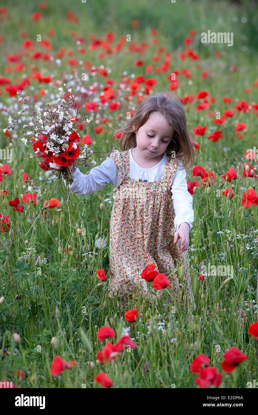 Gard, Frankreich Aigues Vives, ein junges Mädchen in einem Feld von Mohn Stockfoto