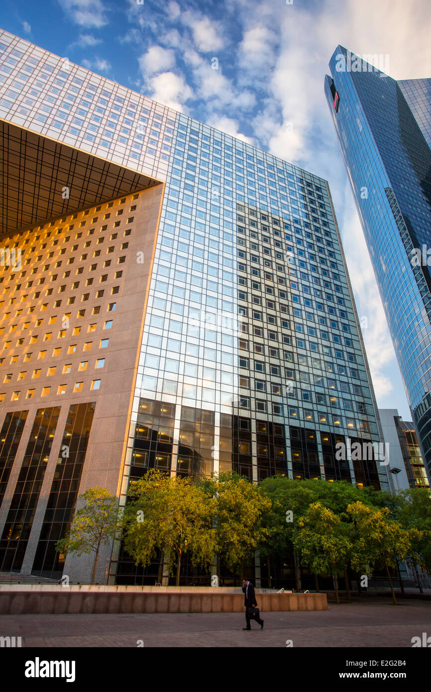 Mann zu Fuß vorbei an einigen der modernen Architektur von La Défense, Paris Frankreich Stockfoto