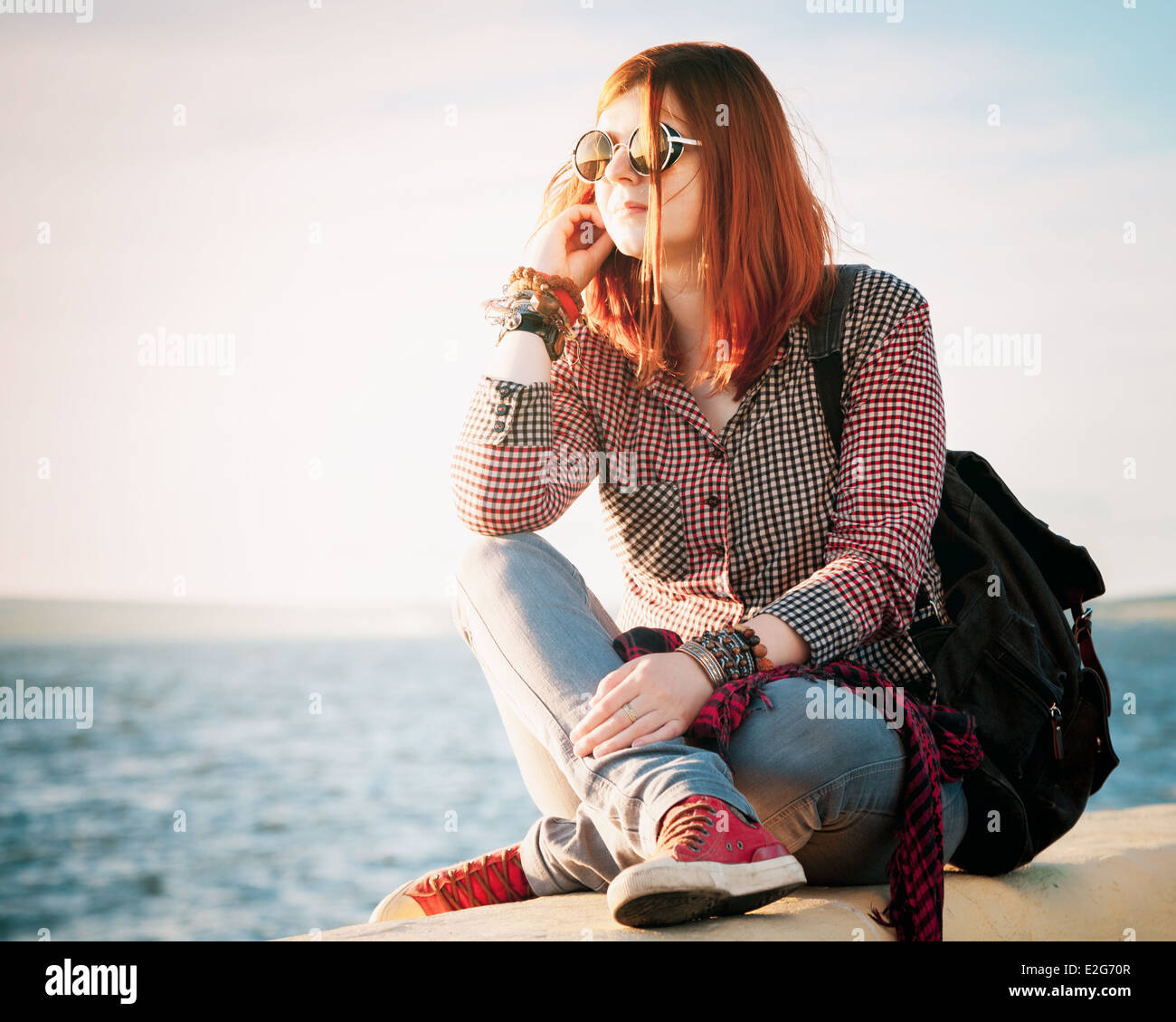 romantisch schöne junge Frau mit Handtasche über Seestück Stockfoto