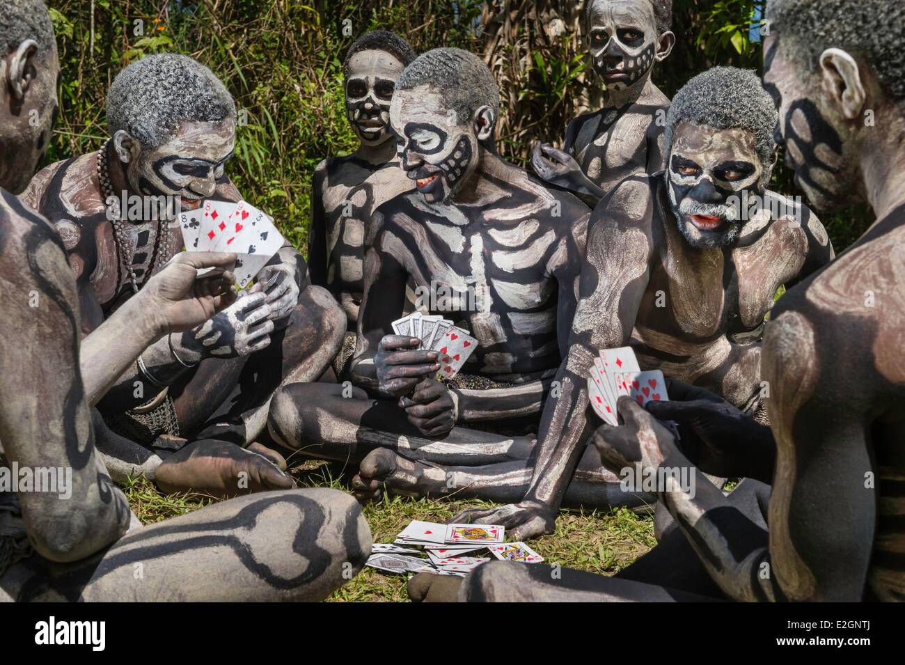 Papua-Neu-Guinea Western Highlands Provinz Waghi Tal Mount Hagen Region Mindima Bamugl Dorf Jugendliche des Stammes von Oma Maslai Skelett Spielkarten in traditioneller Tracht Stockfoto