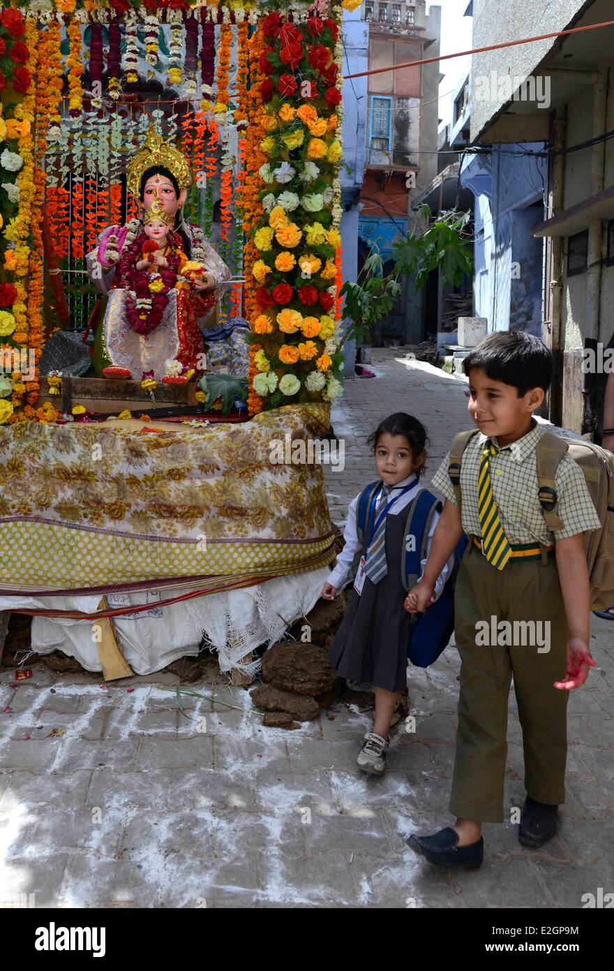 Indien Uttar Pradesh State Mathura zurückkommen ein kleiner Junge und seine kleinen Schwestern zu Hause nach der Schule vorbei an einem Tempel vor Holi Festival feiern Stockfoto