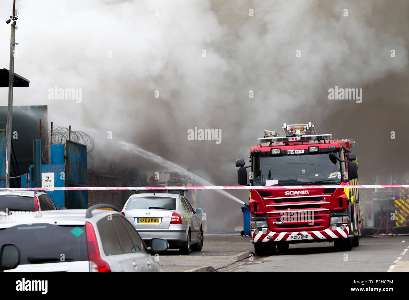 Northampton, UK. 20. Juni 2014. Dämpfe und Rauch verteilt viel von Northampton heute Morgen durch einen großen Brand auf einem Schrottplatz EMR (European Metal Recycling Limited) in Harvey Road, St. James, Northampton, die um Mitternacht begonnen. Harvey-Straße wurde abgesperrt. Die Feuerwehr verwendet ein Cobra-remote-Fahrzeug, um mit dem Feuer. Häuser und Fabrik Einheiten beraten gewesen, halten Türen und Fenster schließen Becase giftige Dämpfe aus der Verbrennung von Reifen und Kunststoffe. Bildnachweis: Keith J Smith. / Alamy Live News Stockfoto