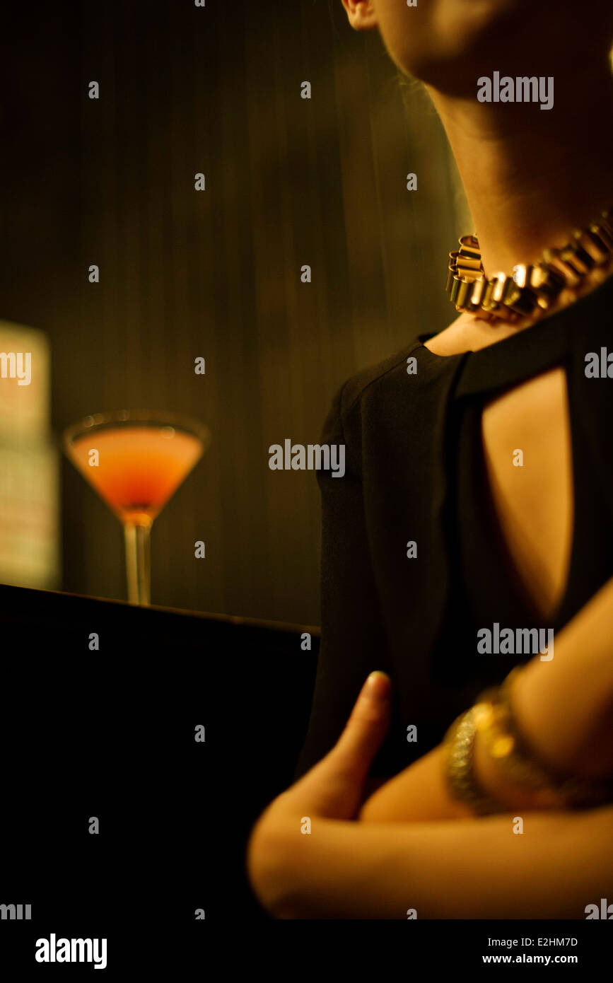 Frau sitzt allein an Night Clubbar Stockfoto