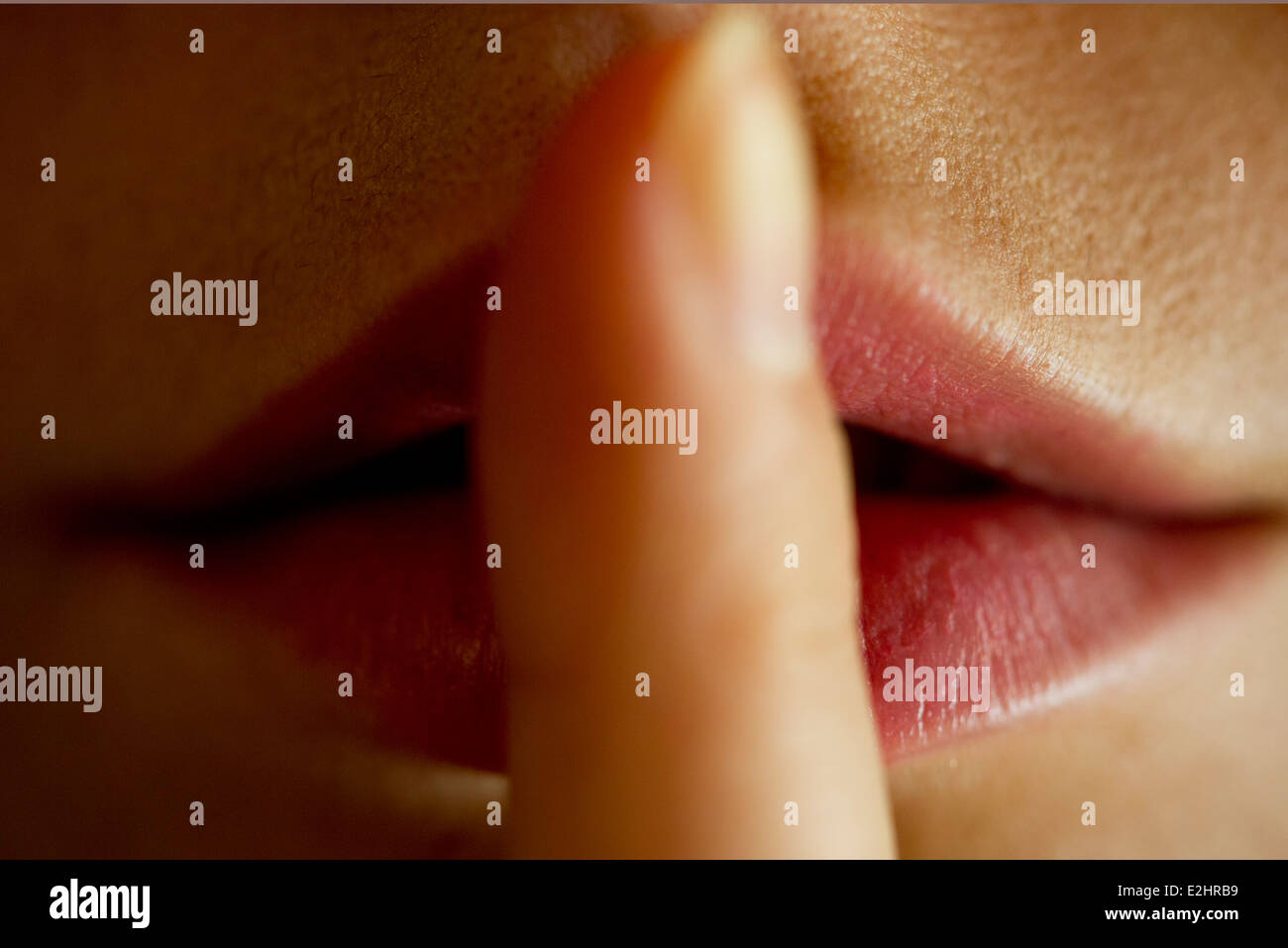Frau mit Finger auf die Lippen Stockfoto