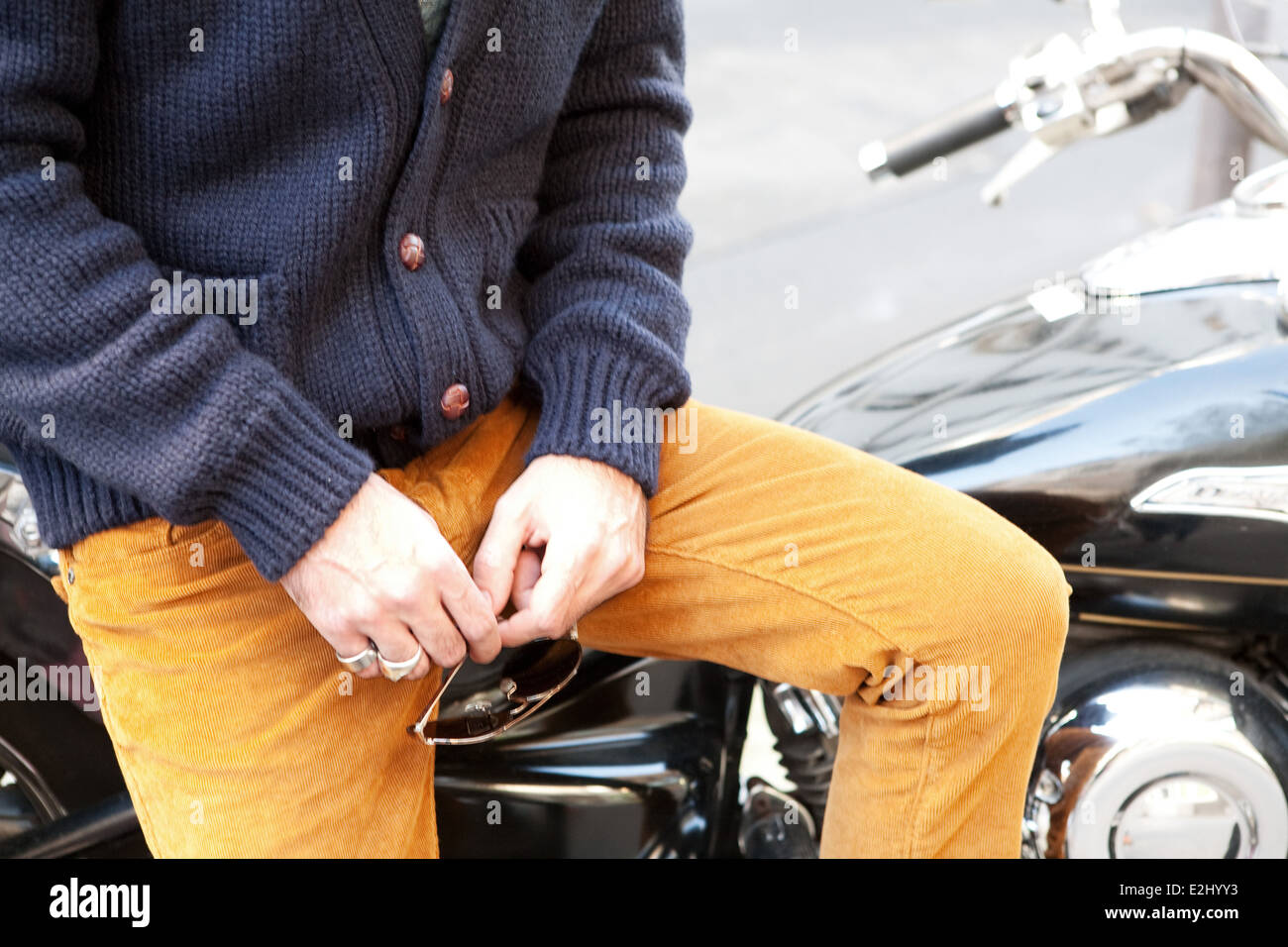 Mann sitzt auf dem Motorrad mit Sonnenbrille in der Hand, beschnitten Stockfoto