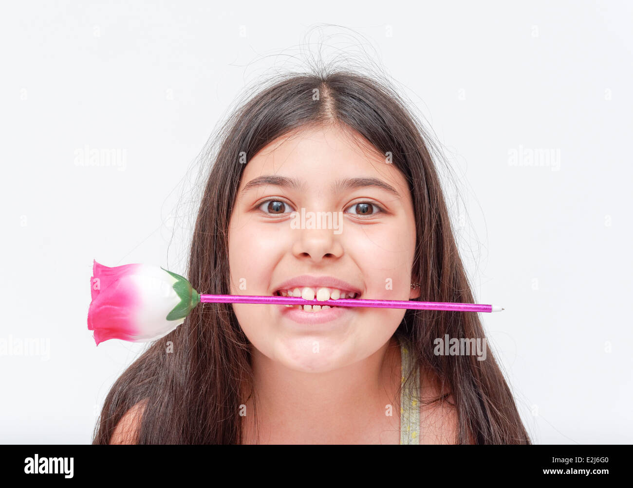 fröhliches junges Mädchen von 9 mit einer Blume im Mund Model release verfügbar Stockfoto