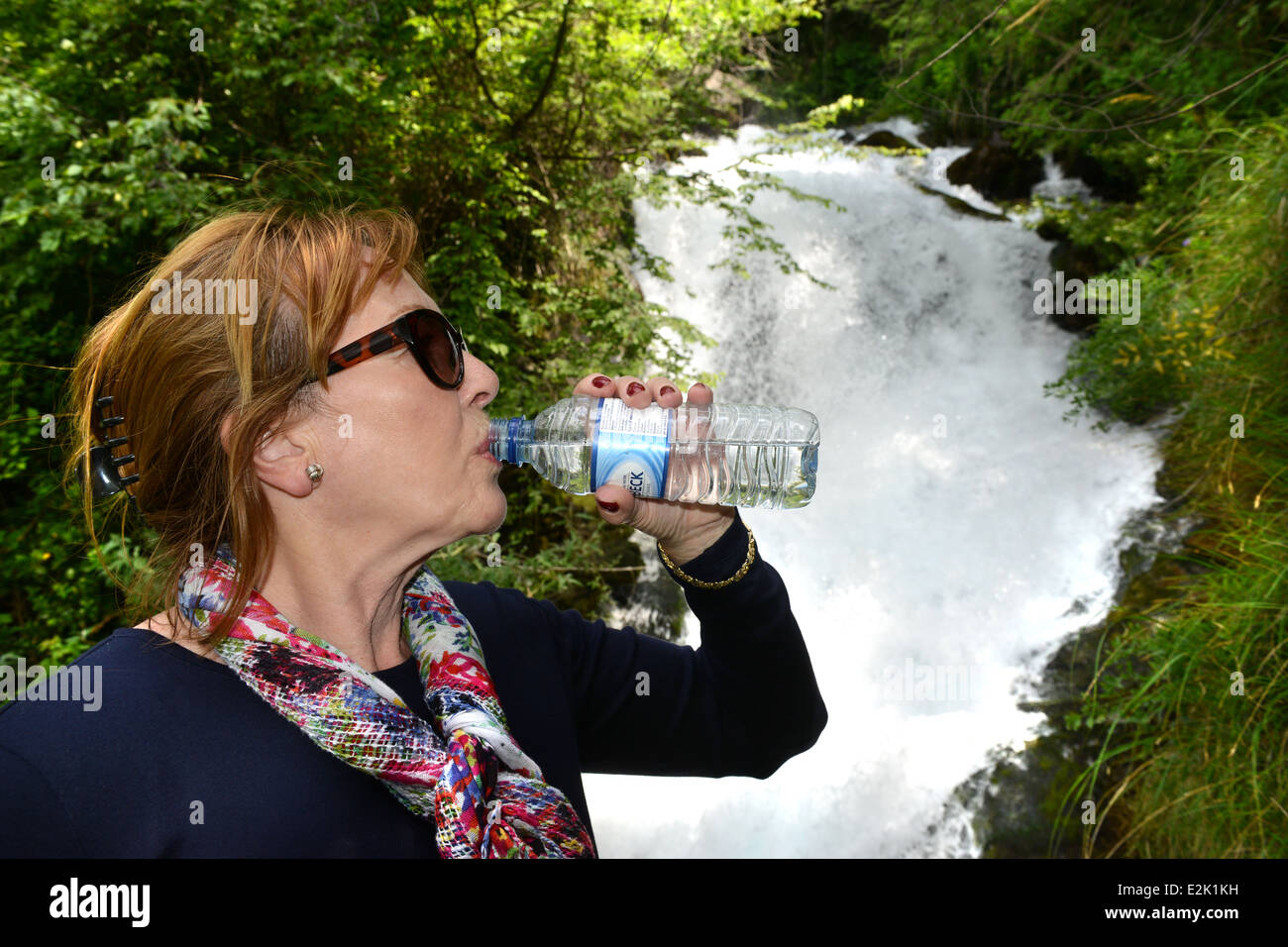 Frau trinkt Mineralwasser natürliche nächste Fiumelatte Fluss Varenna Lombardei Italien Stockfoto