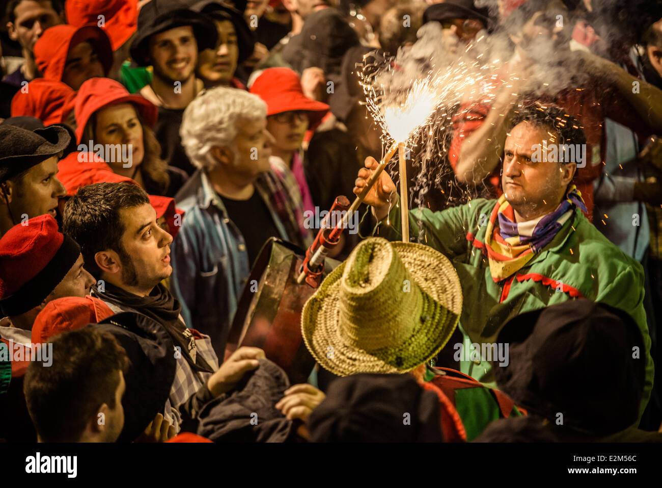 Berga, Spanien. 19. Juni, 2014:A Mitglied des Arbeitskreises "Dämonen Keulen schwingende" bekommen seine Feuerwerkskörper erleuchtet für die Leistung während der ersten kompletten Patum 2014 in Berga Credit: Matthi/Alamy Live-Nachrichten Stockfoto