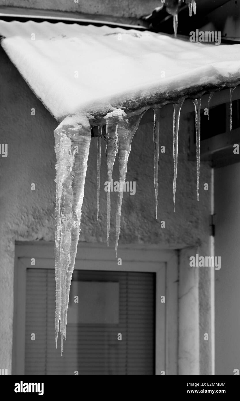 transparente Eiszapfen auf dem Dach Stockfoto