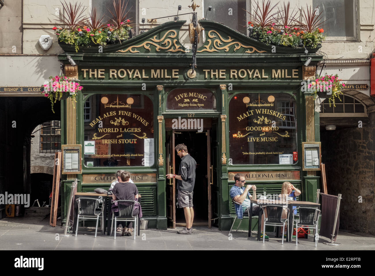 Kellner und Touristen genießen einen Drink an der Vorderseite der Royal Mile-Taverne-Edinburgh Stockfoto