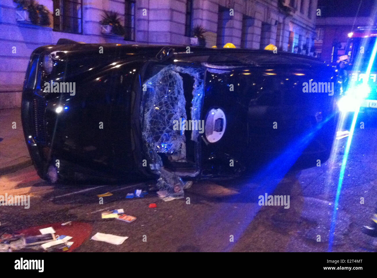 London Taxi-Fahrer hatte eine wunderbare Rettung, nachdem ein Auto ein rotes Licht auf der Euston Road sprang und an der Seite seines Fahrerhauses zerschlagen senden es ins Schleudern, und am Ende auf seiner Seite. Der Fahrer wurde im Inneren gefangen, aber gelungen, seinen Ausweg th zu zerschlagen Stockfoto