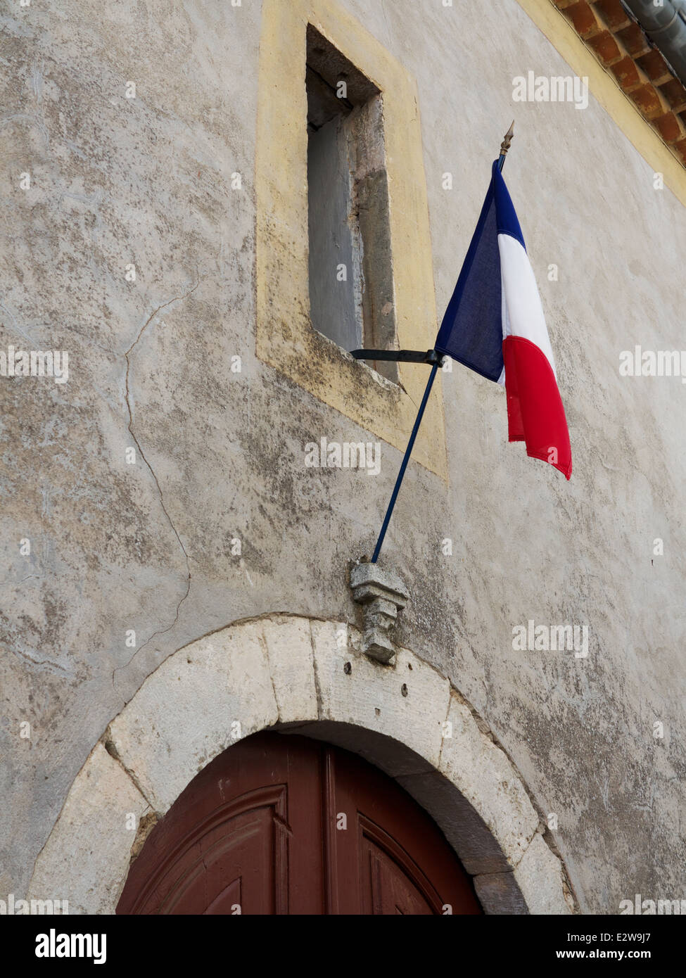Französische Flagge über der Tür in einem ländlichen Dorf im Hérault, Südfrankreich Stockfoto