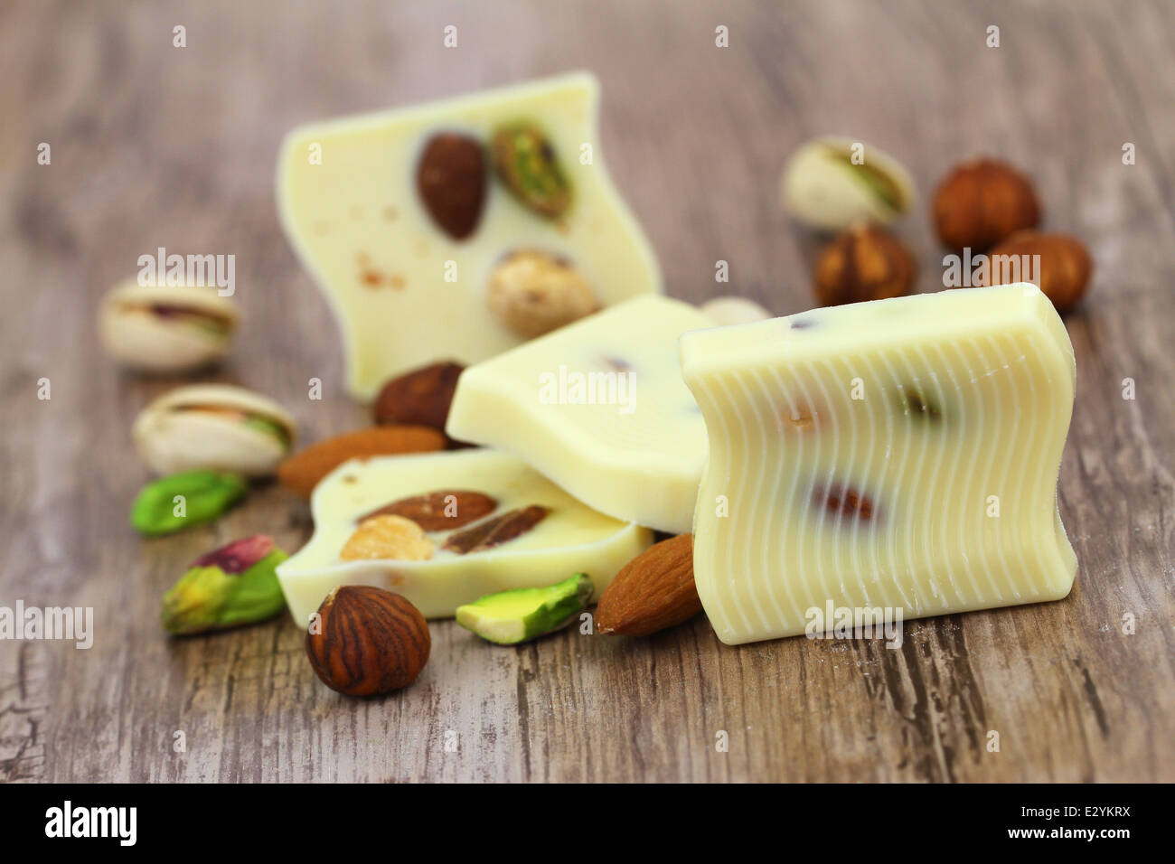 Weiße Schokolade Stücke mit Mandeln, Pistazien und Haselnüssen Stockfoto