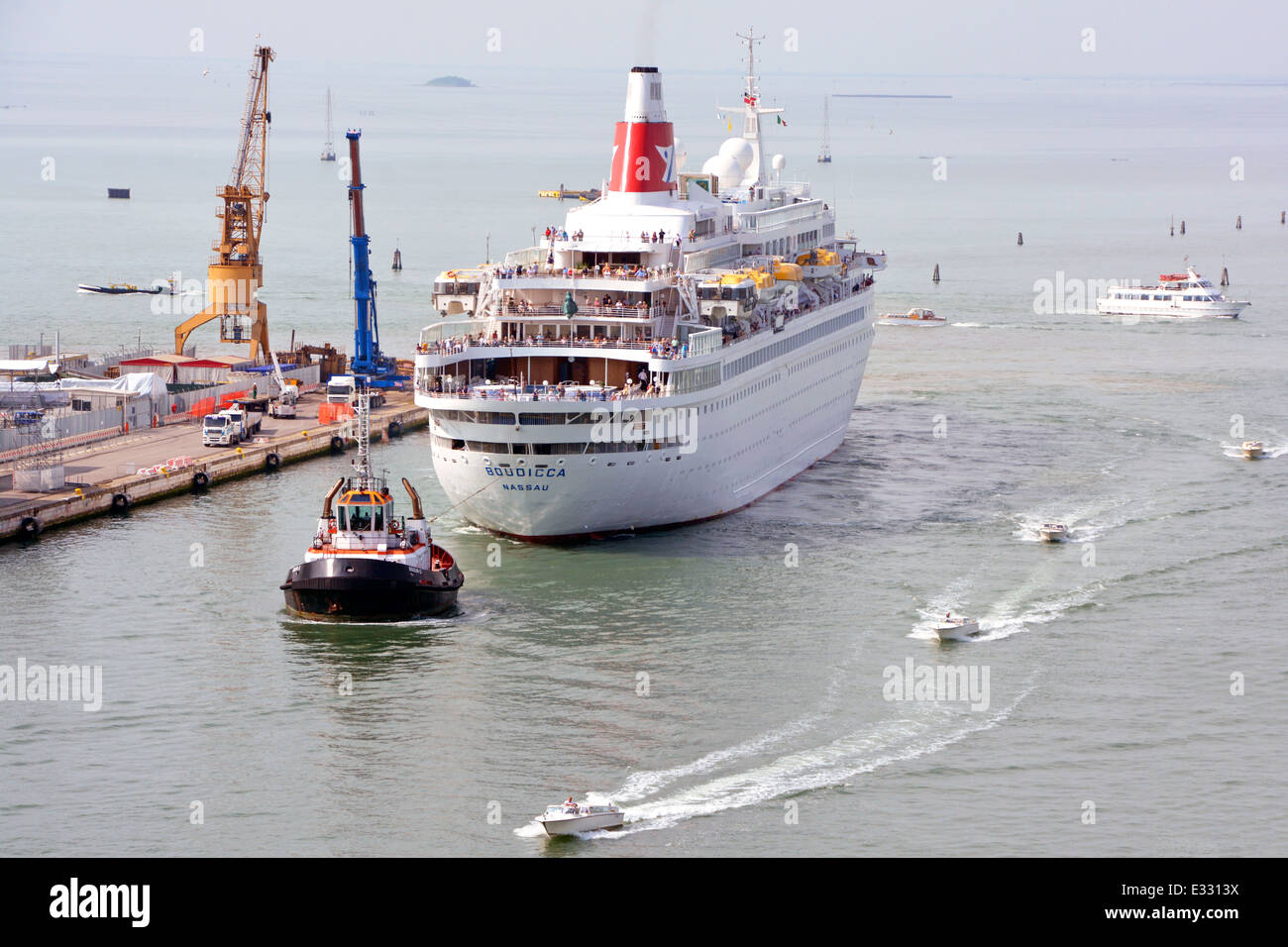 Passagiere an Deck des Kreuzfahrtschiffes Boudicca von Fred Olsen Lines werden mit dem Schlepper zur Geburt für den Sommerbesuch im Hafen von Venedig Italien geschleppt Stockfoto