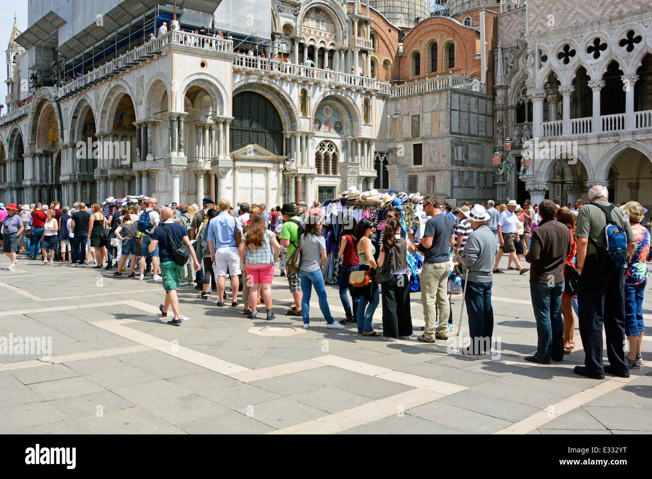 Lange Schlange für Sommertouristen, Leute in legerer Kleidung, die draußen Schlange stehen Italienischer Dogenpalast in Richtung der geschäftigen historischen Markusbasilika Venedig Venetien Italien Stockfoto