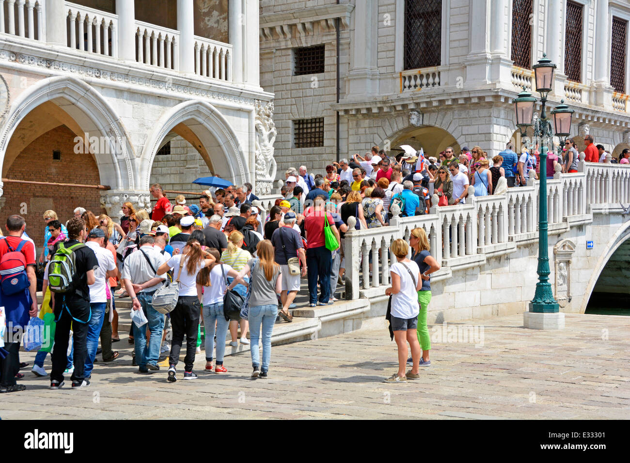 Massen Sommer Sightseeing Touristen zu Fuß über Fußgängerbrücke über den schmalen Kanal Brücke zwischen den Ecken von Doges Palace & New Prison Venice Venetien Italien Stockfoto
