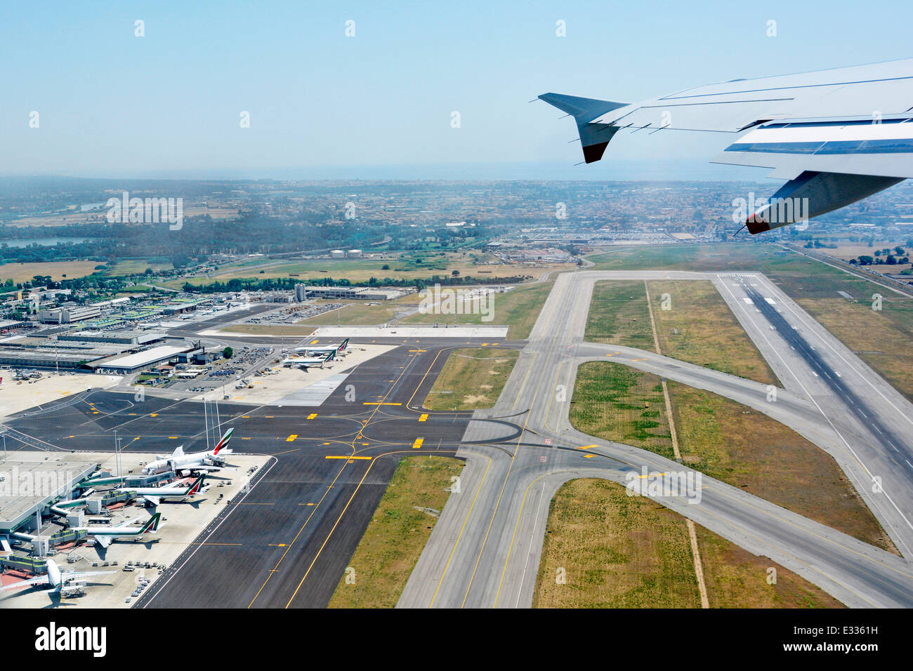 Flugzeug aus der Vogelperspektive auf die Start- und Landebahn und die Rollwege zu den Terminalgebäuden vom Jet über dem italienischen Flughafen Rom Fiumicino in Italien Stockfoto