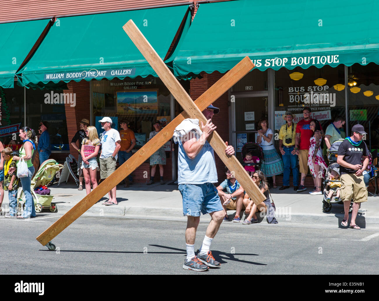 Religiöser Mensch trägt ein hölzernes Kreuz in jährlichen FIBark-Parade in kleinen Bergstadt Salida, Colorado, USA Stockfoto